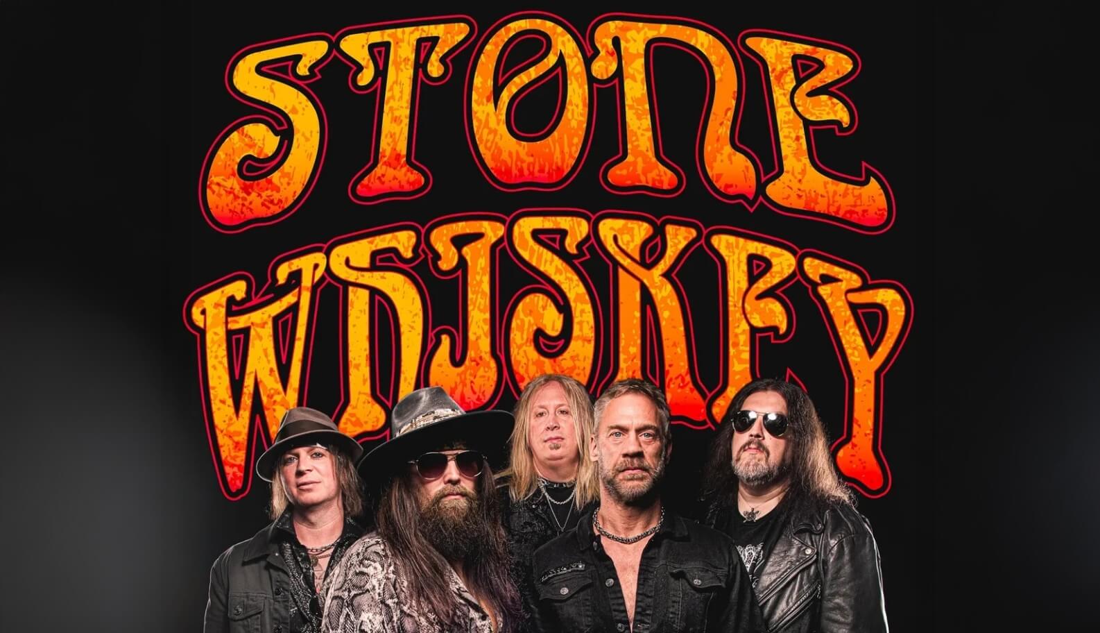 | The Mountain Music Festival Fiery orange ‘STONE WHISKEY’ logo dominates the image as five rock musicians stand in front, black background behind them.